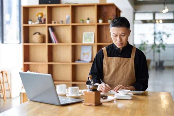 飲食店経営者が計算している