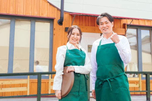 ガッツポーズをしているカフェ男性店員とカフェ女性店員