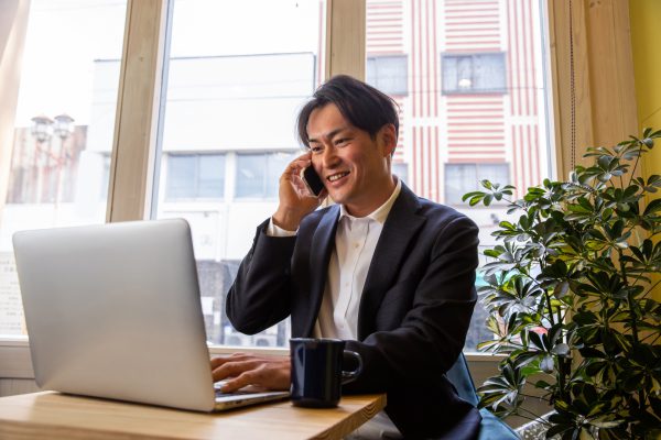 カフェで電話をする店舗経営者